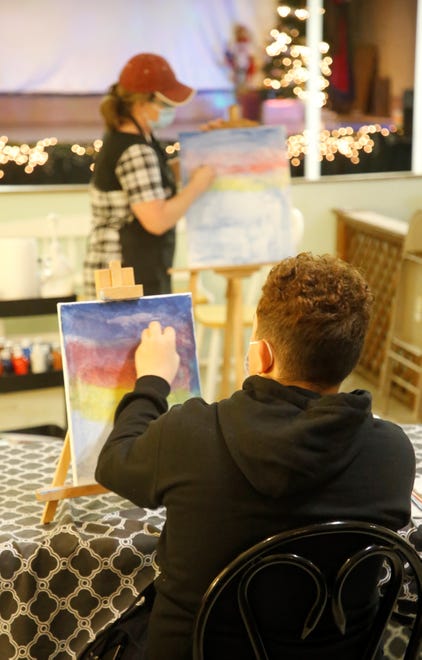Student Jayden Fitzgerald follows the instructions of CEO Christy Clugston during a Dec. 29, 2020, painting class at Inspire heART at the Aztec Theater.
