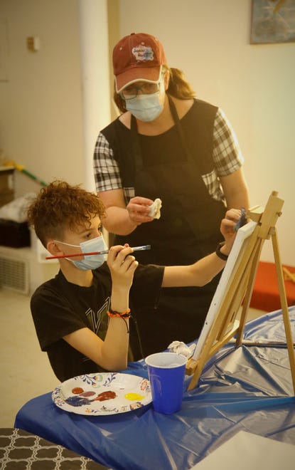 CEO Christy Clugston offers student Caleb Richins some advice as he works on his painting Dec. 29, 2020, at Inspire heART at the Aztec Theater.