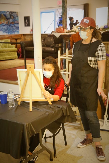CEO Christy Clugston looks over the shoulder of student Emmie Fitzgerald during a Dec. 29, 2020, painting class at Inspire heART at the Aztec Theater.