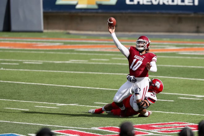 Jonah Johnson (10) passes as he's taken down as New Mexico State takes on Dixie State at the Sun Bowl in El Paso, Texas on Sunday, March 7, 2021.