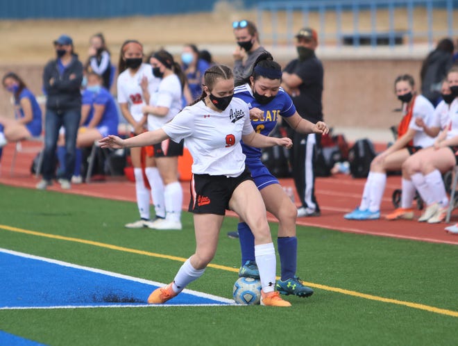 Aztec's Ashle Sexton and Bloomfield's Telaya Wero battle for possession of the ball on Saturday, March 6, 2021, at Bobcat Stadium in Bloomfield.