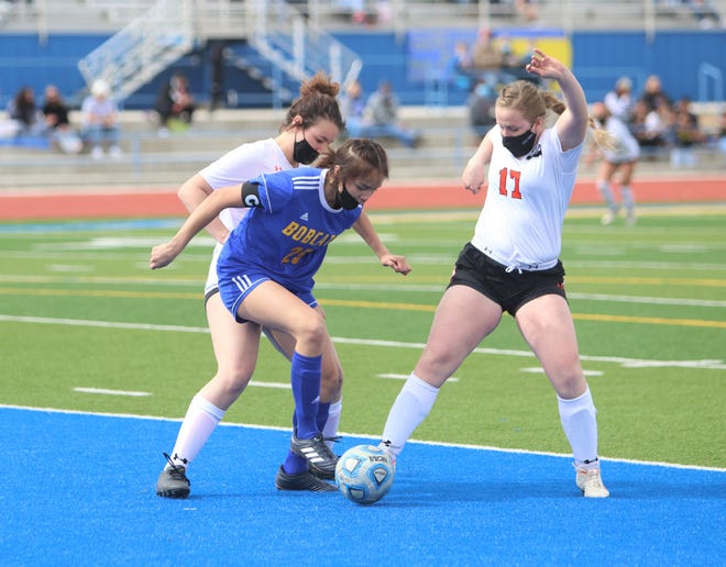 Bloomfield's Madison Bedonie tries to control the ball against Aztec's Aspen Newland and Denym Seabolt (17) on Saturday, March 6, 2021, at Bobcat Stadium in Bloomfield.