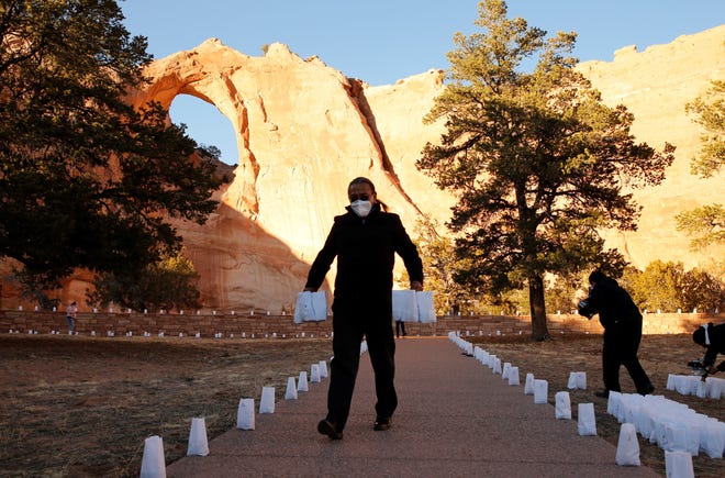 Cal Curley, legislative and government affairs associate with the Navajo Nation Washington Office, helps set up luminarias for a memorial service on March 17 in Window Rock, Arizona.