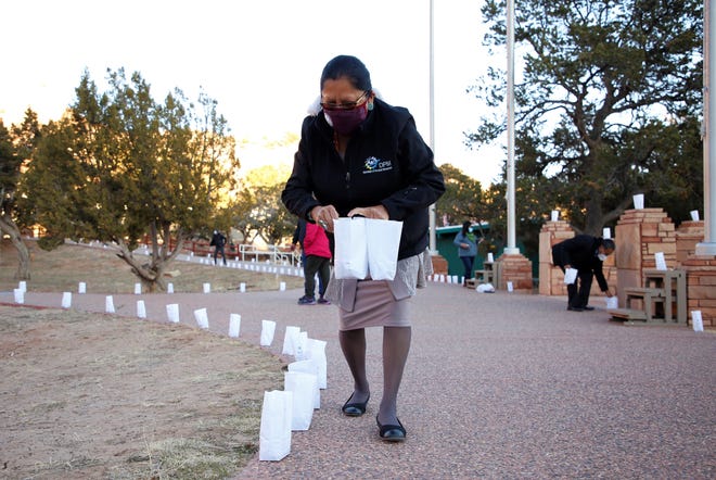 Perphelia Fowler, director of the Navajo Nation Division of Human Resources, places luminarias for a memorial event on March 17 in Window Rock, Arizona to remember tribal members who died of COVID-19.