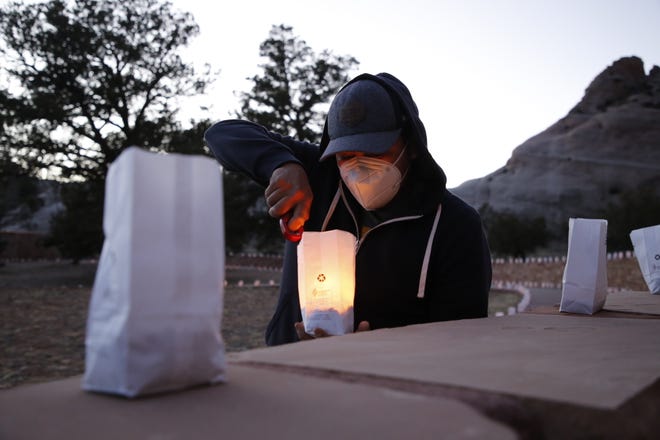 Kendrick James, staff assistant with the Navajo Nation Office of the President and Vice President, lights a candle on March 17 for an event in Window Rock, Arizona to remember tribal members who died of COVID-19.