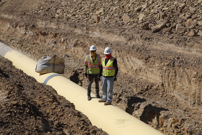 Construction workers watch activity on the Navajo-Gallup Water Supply Project on April 15 in Newcomb.