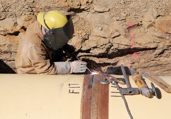A welder puts together a section of pipe as part of the Navajo-Gallup Water Supply Project on April 15 in Newcomb.
