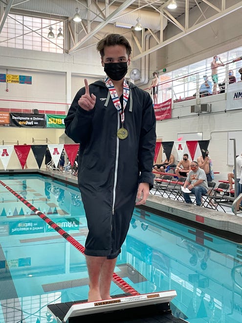 Farmington diver Mosiah Seavey displays his first place medal in the 1-meter dive at the 5A state swimming championships on Saturday, May 15, 2021, at Albuquerque Academy.