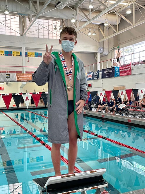 Eddie Durphy displays his second place medal in the 1-meter dive at the 5A state swimming championships on Saturday, May 15, 2021, at Albuquerque Academy.