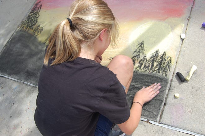 Abbigail Jaramillo uses her fingertips to smooth the foreground of her entry in the Chalk Art Competition outside the Farmington Public Library on June 10.