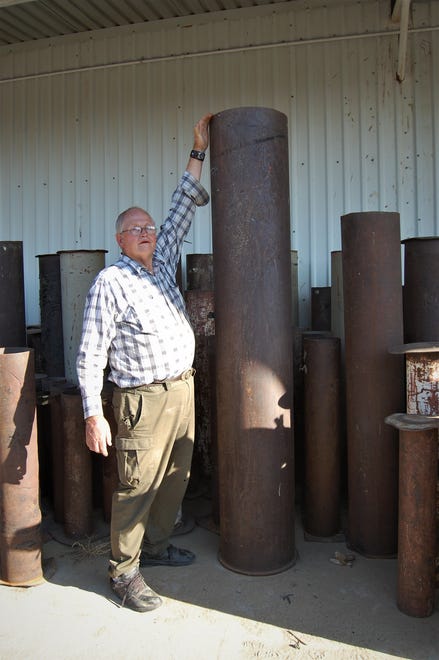 Tommy Bolack reaches to the top of a 8-foot mortar tube that is used in his annual Fourth of July fireworks show from the B-Square Ranch.