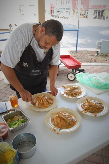 Chef Neil Johnson puts the final touches on his lamb etouffee dish before presenting plates to the judges during a cook-off on July 15 in Orchard Park in downtown Farmington.