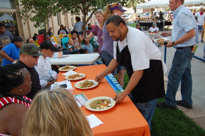 Chef Neil Johnson serves his lamb etouffee dish to the judges during the Northwest New Mexico Local Food Summit cook-off on July 15 in Orchard Park in downtown Farmington.