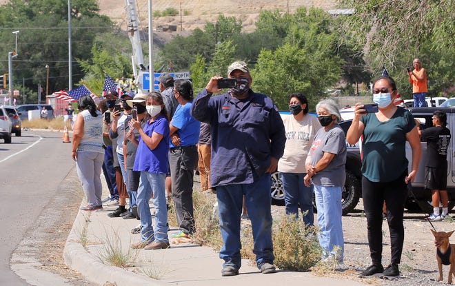 Community members watch on July 19 the motorcade escorting family members of U.S. Army veteran Cecelia B. Finona to Desert View Funeral Home in Shiprock after her remains arrived at Albuquerque earlier in the day.
