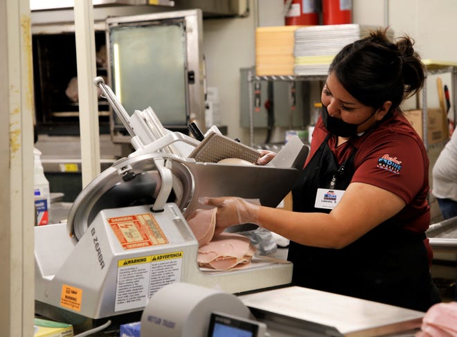 Lakeisha Bryant, lead cook at the Bashas' Diné Market in Tuba City, Arizona, slices turkey meat on July 20 as part of a training session for employees in Shiprock. The Bashas' Family of Stores acquired the City Market grocery store and added the location to its brand.
