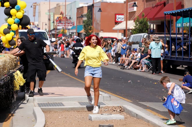 A participant in the 2021 Connie Mack World Series parade prepares to toss candy to spectators on July 22 in downtown Farmington.