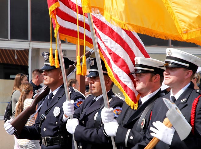 The Farmington Police Department and the Farmington Fire Department carry the United States and New Mexico state flags during the 2021 Connie Mack World Series parade on July 22 in downtown Farmington.