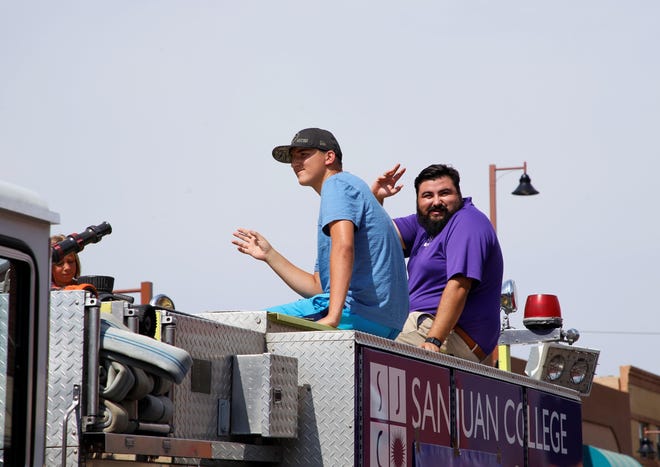 Parade participants from San Juan College wave to spectators during the 2021 Connie Mack World Series parade on July 22 in downtown Farmington.