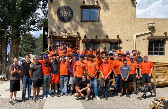 Members of the Aztec Tiger football team, shown here outside 550 Brewing,  volunteered to assist Aztec Main Street businesses with clean up tasks last Friday. This collaborative event was led by student-athletes, with the assistance of the Tiger Booster Club