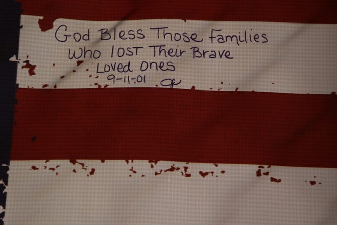 A note is written on a tattered American flag, hanging at Ricketts Park, paying tribute to the 343 firefighters who lost their lives on Sept. 11, 2001.
