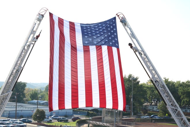 The American flag, hanging off the tops of ladders from local firetrucks, displayed outside Ricketts Park where hundreds gathered to pay tribute to the 343 firefighters who lost their lives on Sept. 11, 2001.