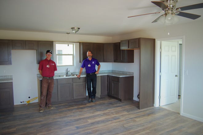 Zachary Pettijohn, left, and Chad Triplett, assistant professors in the building trades program at San Juan College, stand in the kitchen of one of the two new homes built by students in their program that will be showcased during an open house this weekend.