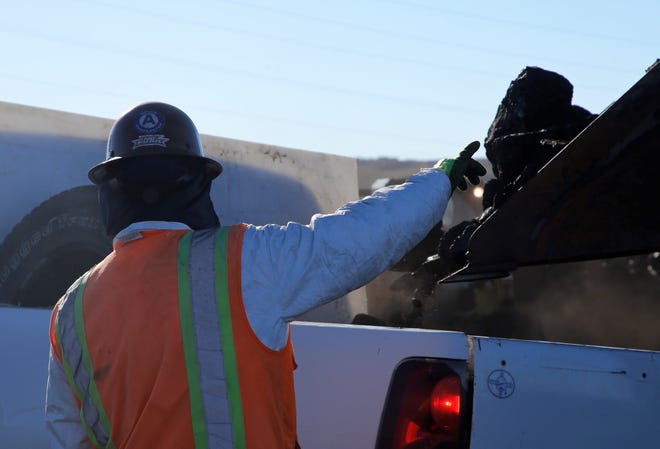 A worker helps direct a loader dumping coal into a pickup truck bed on Oct. 13 during the opening day of the Community Heating Resource Program at Navajo Mine.