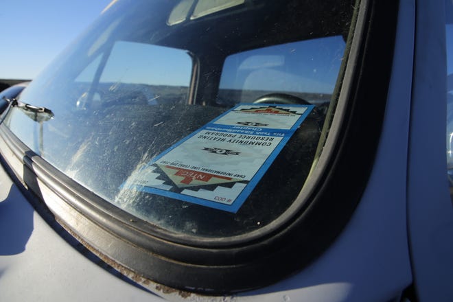 A ticket for free coal from Tiis Tsoh Sikaad Chapter sits on the dashboard of Daniel Barber's truck while he waits for the coal yard at Navajo Mine to open on Oct. 13.