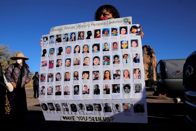 Meskee Yatsayte, founder of Navajo Nation Missing Persons Updates, holds a poster that shows photos of missing members of the Navajo Nation before the start of two awareness walks on Oct. 18 in Window Rock, Arizona.