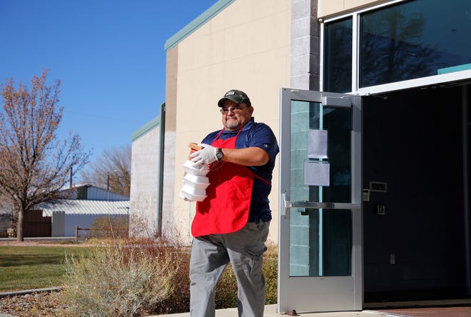 Ernie Arviso carries desserts to-go at the Salvation Army's annual Thanksgiving luncheon on Nov. 25 at the Sycamore Park Community Center in Farmington.
