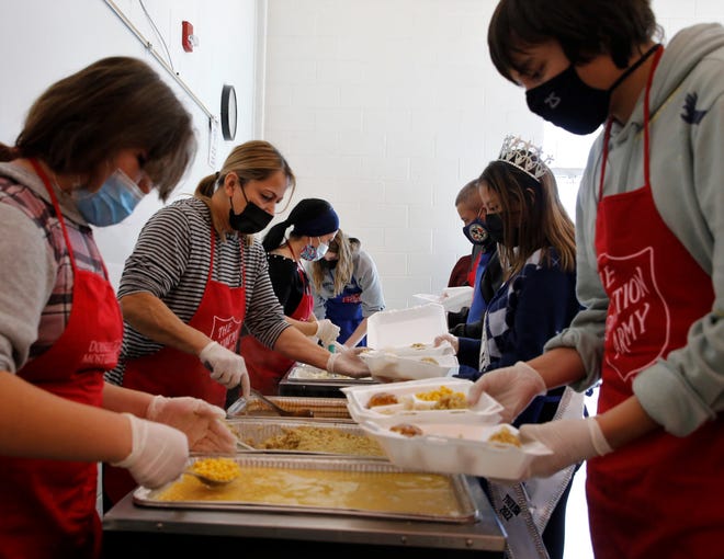 Volunteers prepare carryout food containers at the Salvation Army's annual Thanksgiving luncheon on Nov. 25 at Sycamore Park Community Center in Farmington.