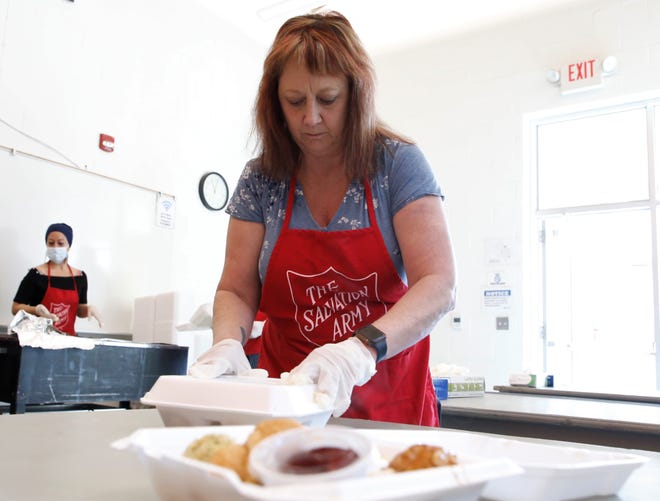 Jacque Payne makes sure carryout food containers have each food item at the Salvation Army's annual Thanksgiving luncheon on Nov. 25 at Sycamore Park Community Center in Farmington.