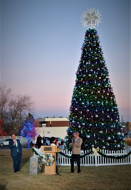 City Councilor Sean Sharer, left, and Jyl Adair and Steve Hansen of Presbyterian Medical Services light the community Christmas tree on the lawn of the Farmington Civic Center on Dec. 2.