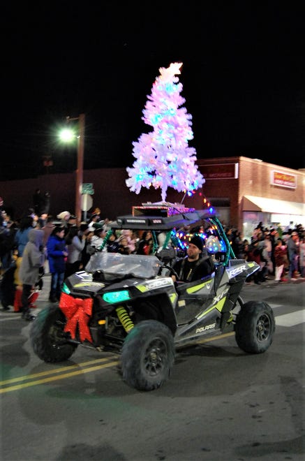 An illuminated Christmas tree rides atop a four-wheel-drive vehicle during the Christmas Parade down Main Street through downtown Farmington on Dec. 2.