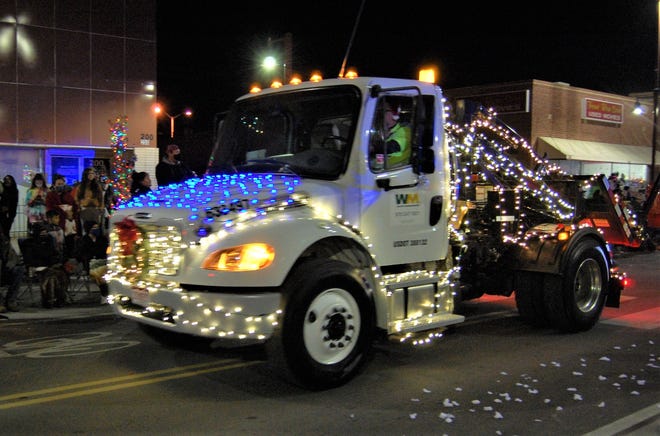 A brightly lit truck from Waste Management Inc. cruises down Main Street during the Christmas Parade through downtown Farmington on Dec. 2.