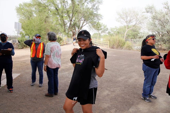Marnissa Begay holds this year's T-shirt for Just Move It on May 11 during a break from walking at Berg Park in Farmington.