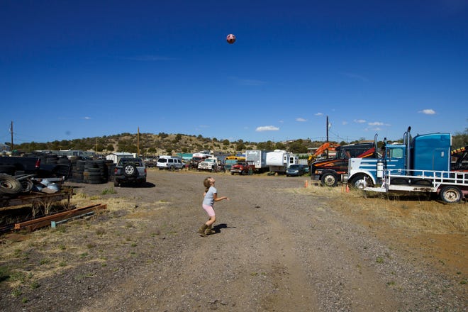 M kicks a soccer ball at home in Silver City, where the family runs a towing business.