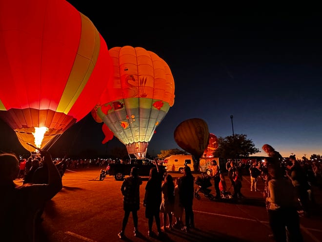 A happy crowd witnesses what they had waited for, a row of balloons firing-up all at once in a San Juan College parking lot Sept. 23 as part of the Four Corners Balloon Rally.